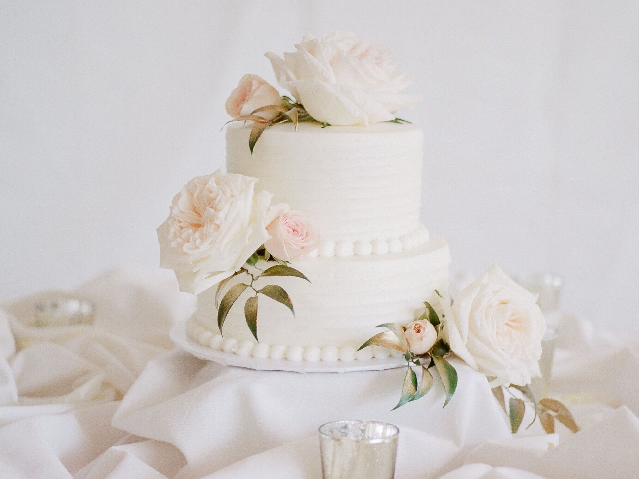 Beautiful white wedding cake with fresh flowers